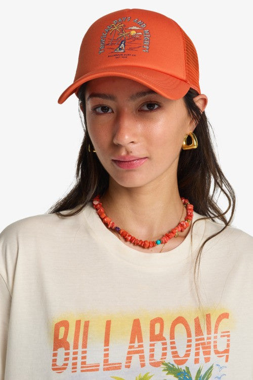 Person wearing an red cap and a Billabong shirt with a necklace.