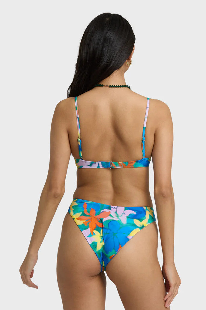Woman wearing a colorful floral bikini set on a white background