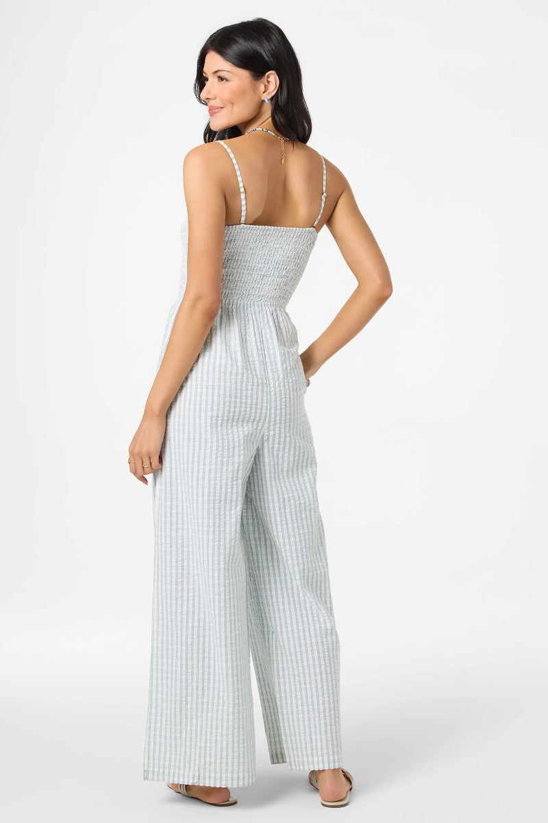 Woman wearing a light blue and white striped jumpsuit on a white background