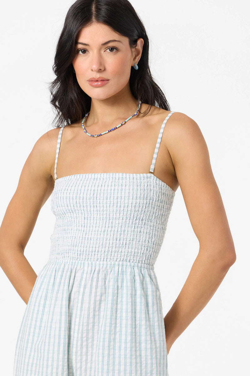 Woman wearing a light blue striped dress against a white background