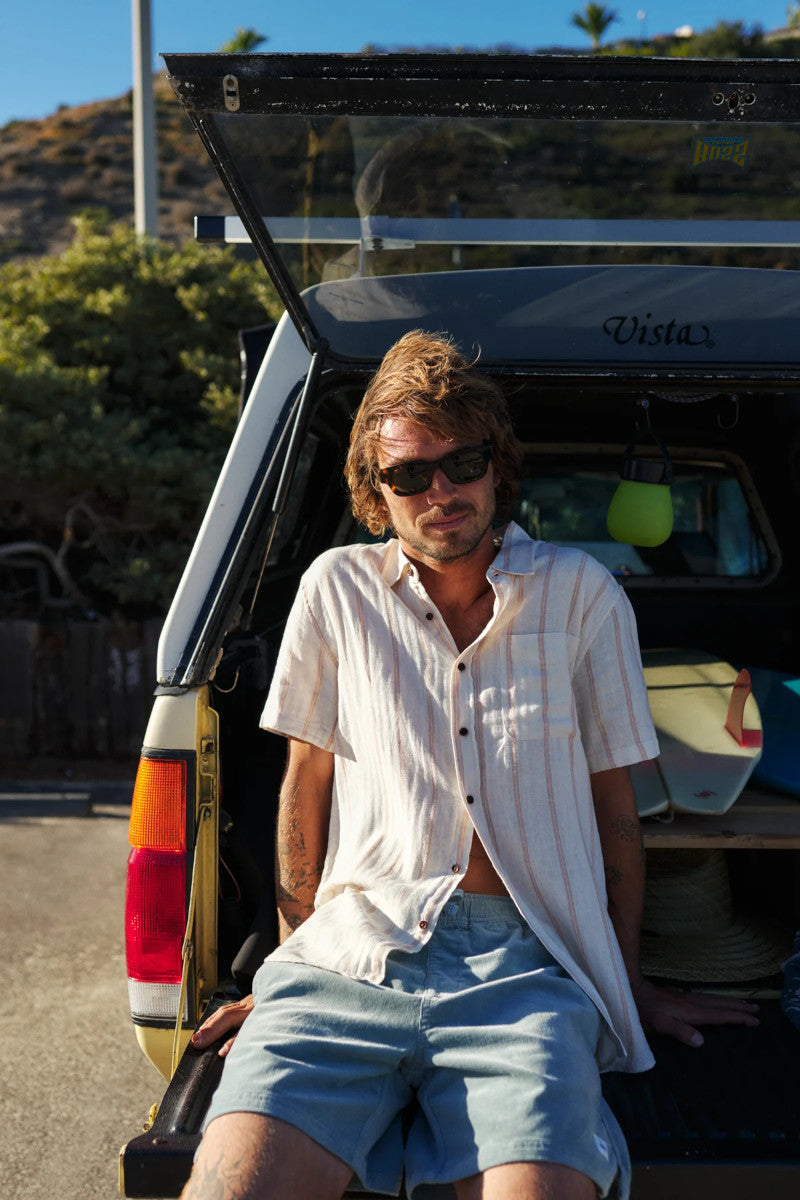 Man sitting in the open trunk of a vehicle with a scenic background