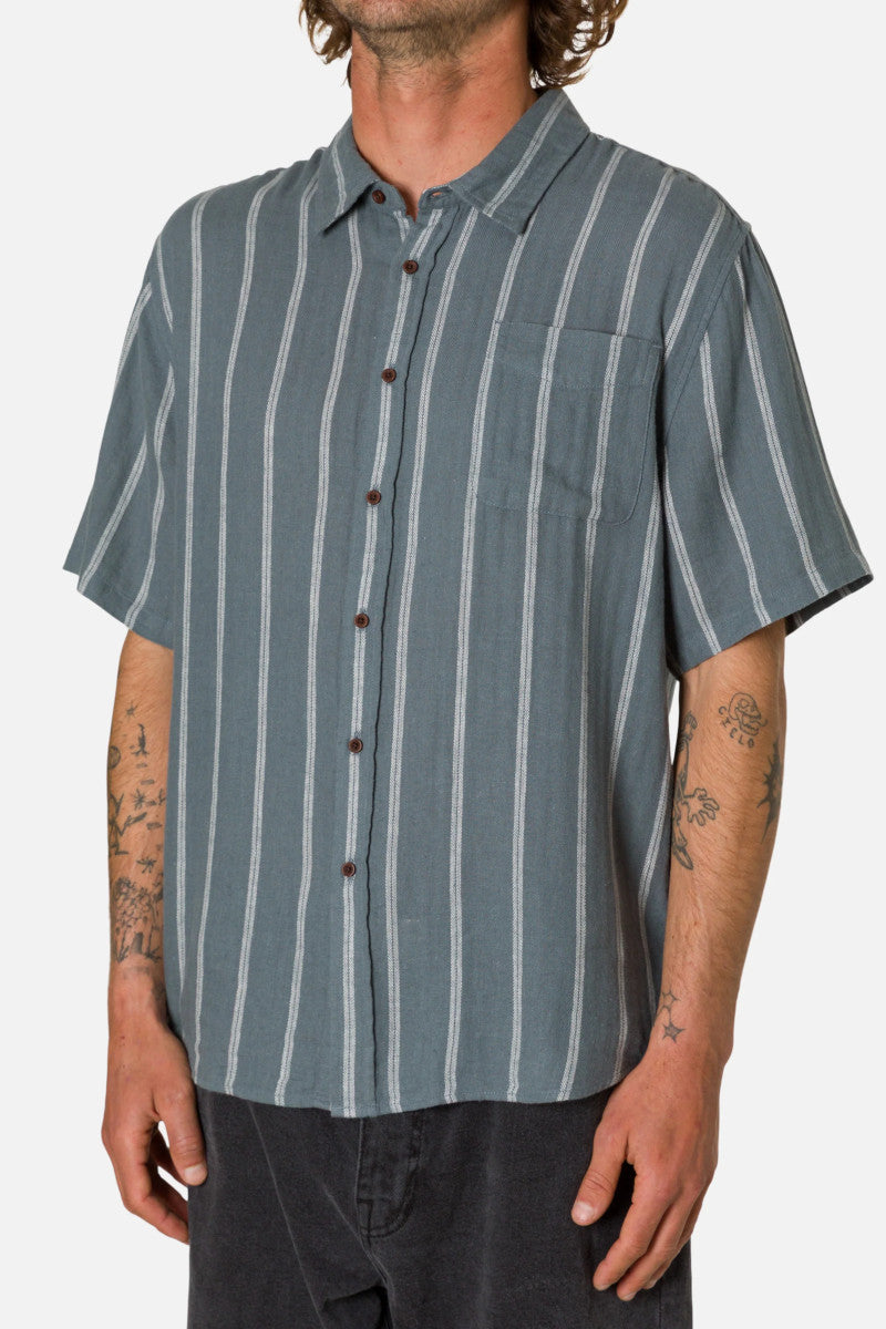 Man wearing a short-sleeve button-up shirt with vertical stripes on a plain background