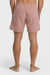 Back view of a man standing and posing in a pair of rose pink boardshorts with a side pocket, featuring an elastic waist closure.