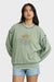 Woman wearing a green sweatshirt with text and graphics on a plain background