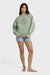Woman wearing a green sweatshirt with a graphic design on a white background