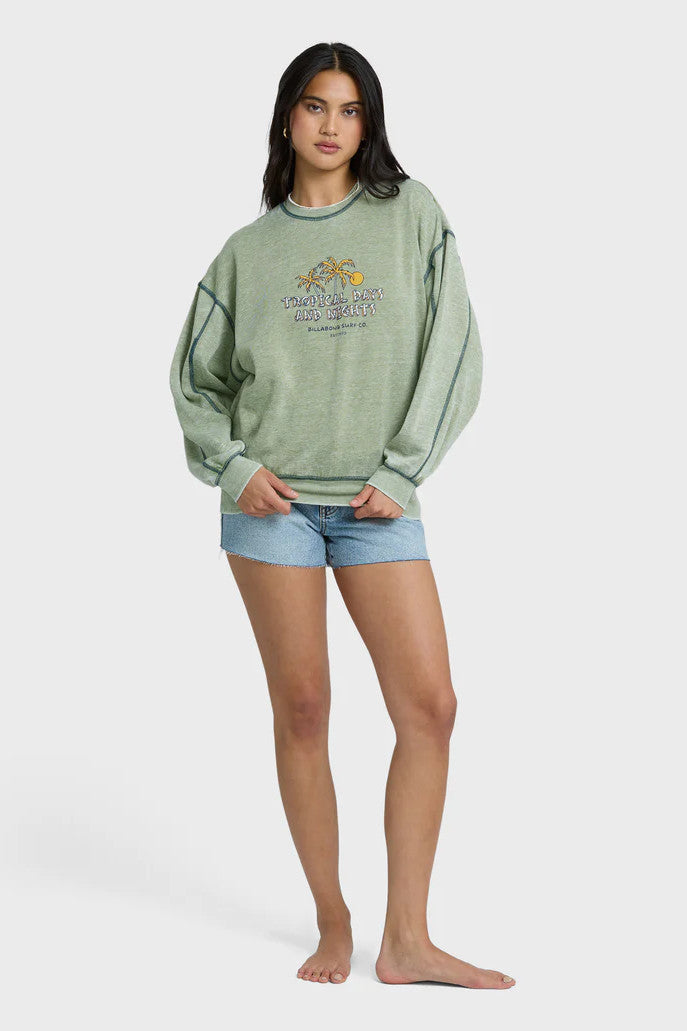 Woman wearing a green sweatshirt with a graphic design on a white background