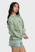 Woman wearing a green sweatshirt with a graphic design on a white background