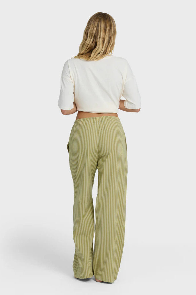 Woman wearing a white top and green striped pants on a white background