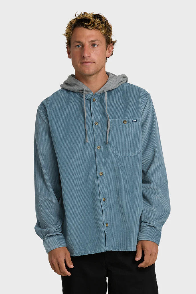 Man wearing a blue corduroy shirt with a gray hood on a white background