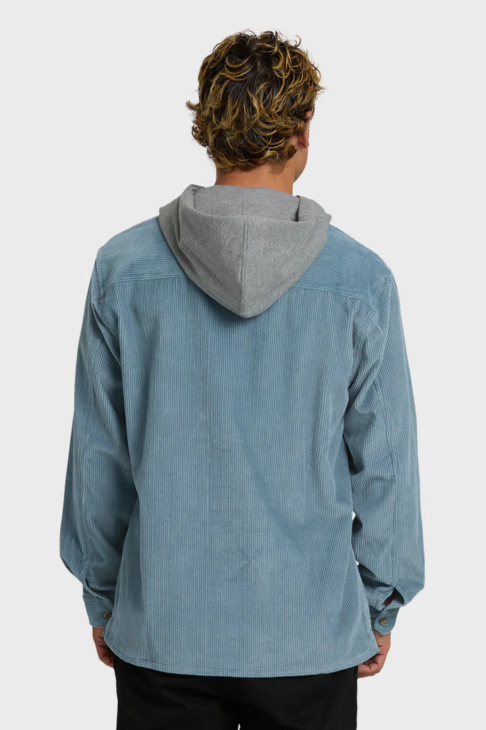 Person wearing a blue corduroy shirt with a gray hood on a white background