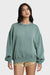 Woman wearing a blue-green sweatshirt with a tonal logo on a white background