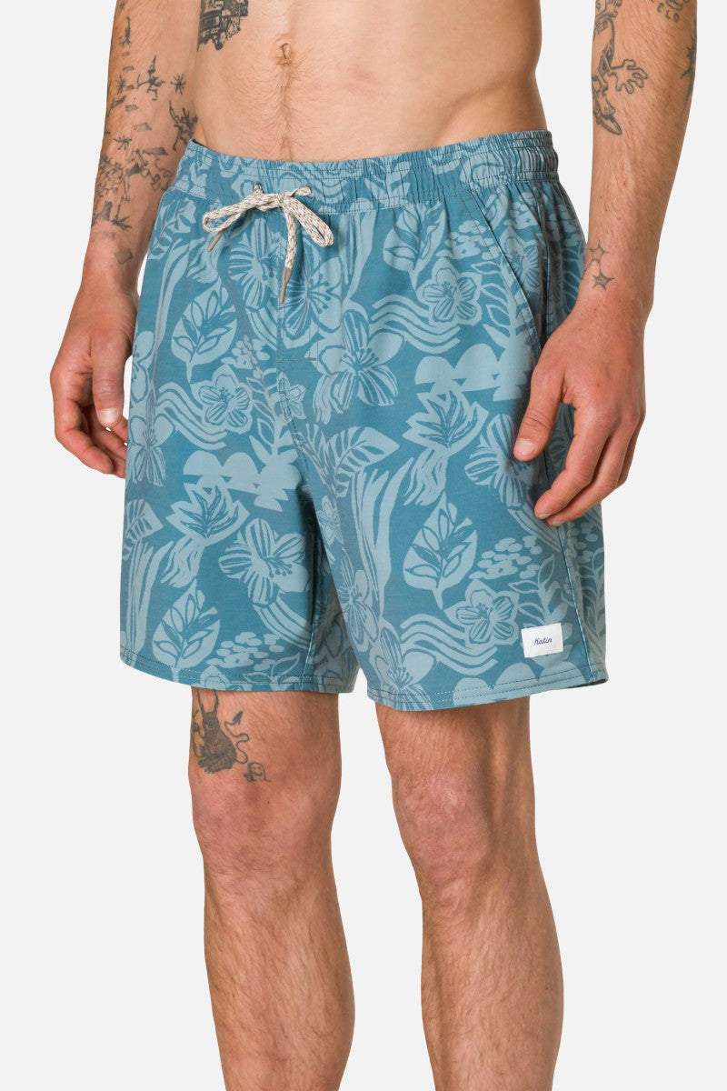 Man wearing blue patterned shorts on a white background