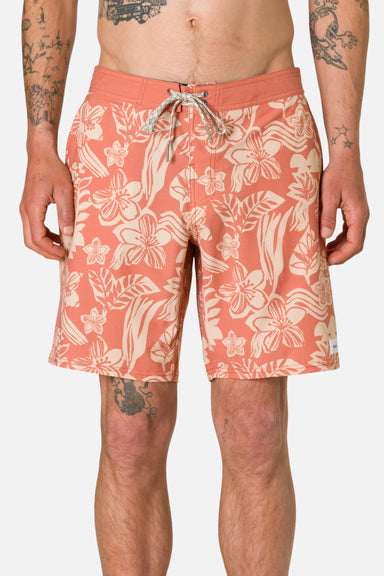 Person wearing coral floral shorts on a plain background