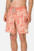 Person wearing coral floral patterned shorts on a plain background