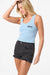Woman wearing a light blue tank top with text and black shorts on a white background