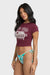 Woman wearing a maroon graphic t-shirt and colorful bikini bottom on a white background