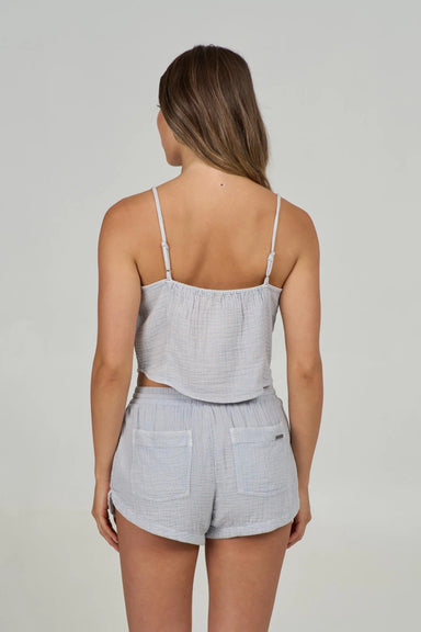 Back view of a woman wearing a light gray tank top and matching gray shorts