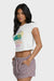 Woman wearing a white graphic t-shirt that says "the art of collecting seashells" and checkered shorts on a white background