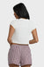 Back view of a woman wearing a white tee and checkered shorts on a white background