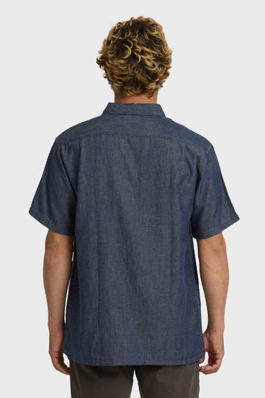Back view of a man wearing a dark blue shirt on a white background