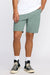 Person wearing green shorts and black sneakers on a white background