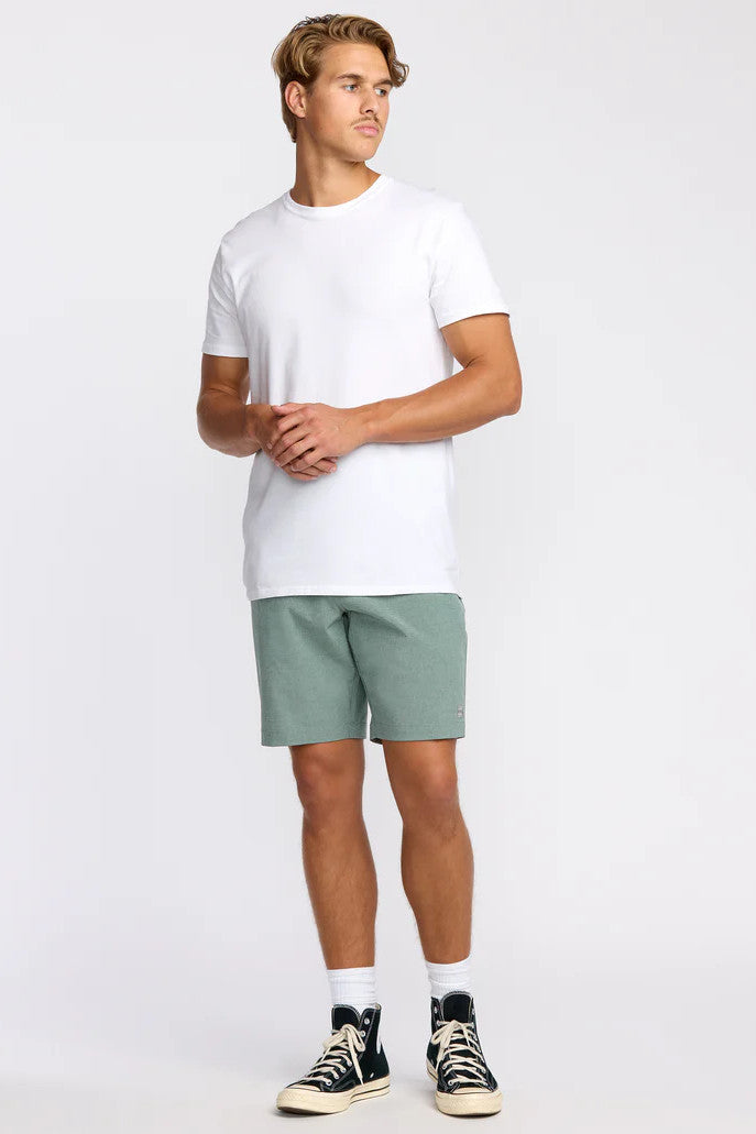 Man wearing a white t-shirt and green shorts on a white background