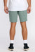 Person wearing green shorts and white sneakers on a plain background