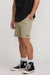 Person wearing beige shorts and black Converse shoes on a white background