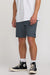 Person wearing navy shorts and black Converse shoes on a white background