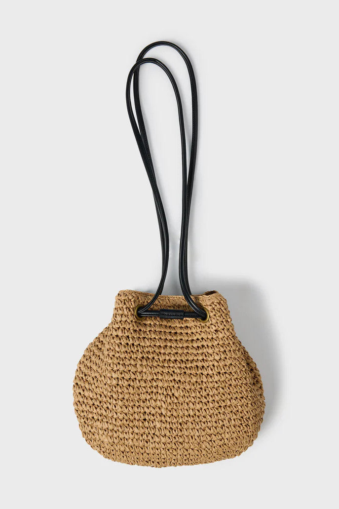 Woven straw bag with a black strap on a light gray background