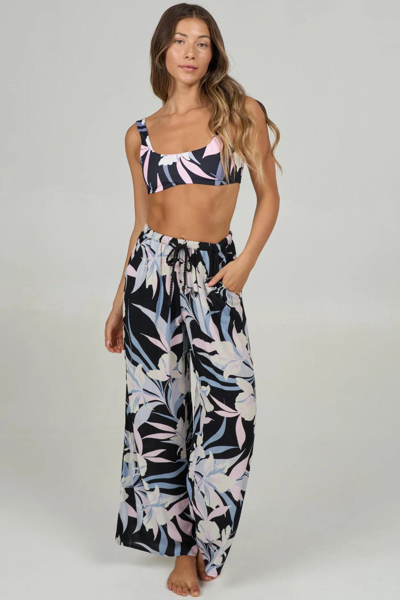 Woman wearing a floral two-piece pant set on a plain background
