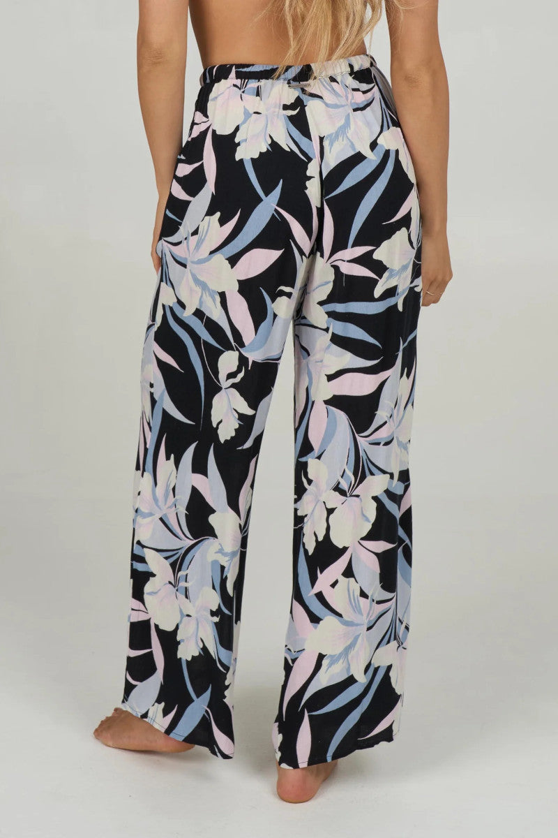 back view of a oman wearing a floral pants on a plain background