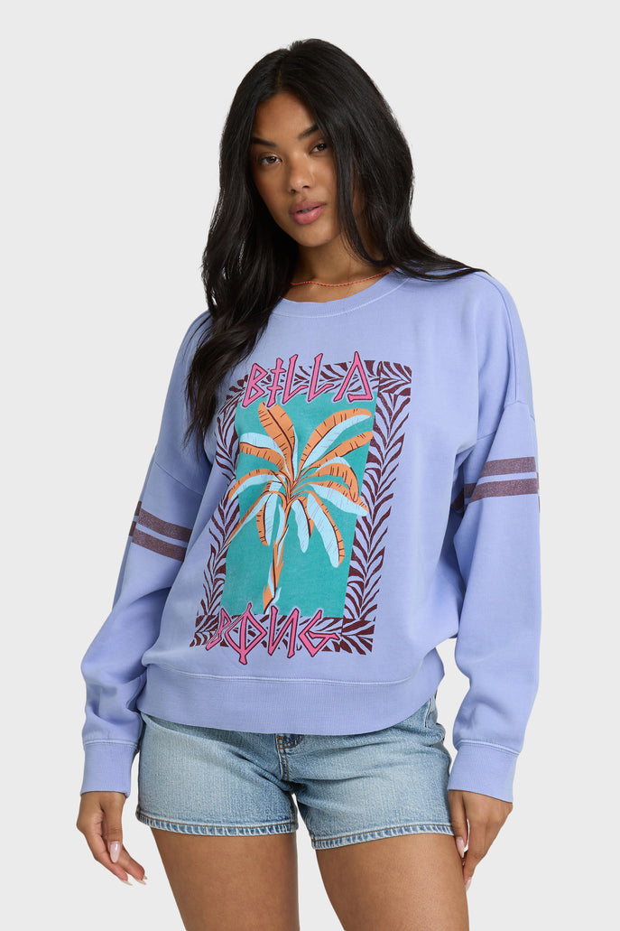 Woman wearing a light blue sweatshirt with palm tree design on a white background