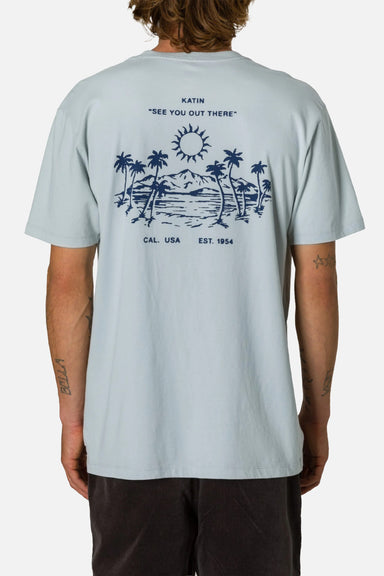 Person wearing a light blue t-shirt with a graphic design on the back