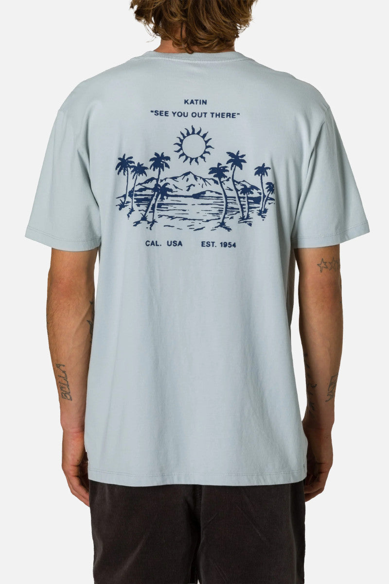 Person wearing a light blue t-shirt with a graphic design on the back