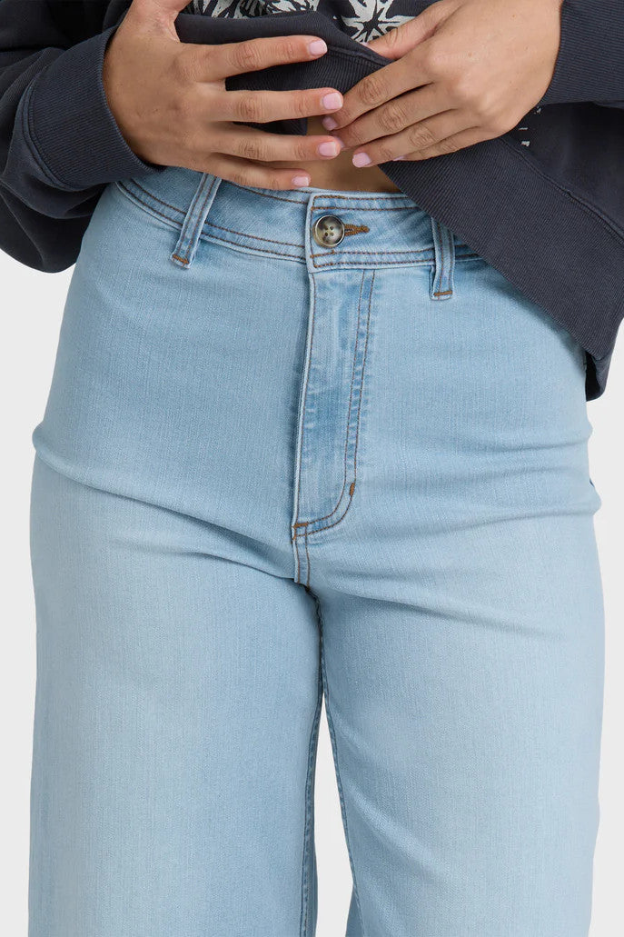 Light blue jeans worn by a person on a plain background