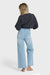 Back view of a woman wearing a charcoal sweater and light blue jeans on a white background