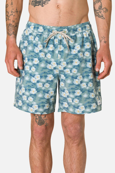 Person wearing blue floral shorts on a plain background
