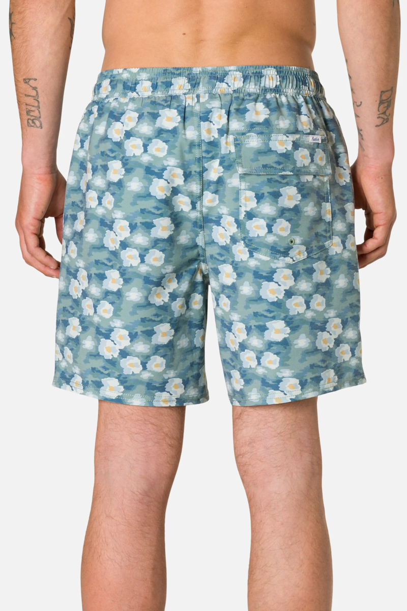 Person wearing blue floral shorts on a plain background