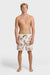 A man wearing cream boardshorts with a floral paisley pattern, elastic waist and drawstring on a white background.