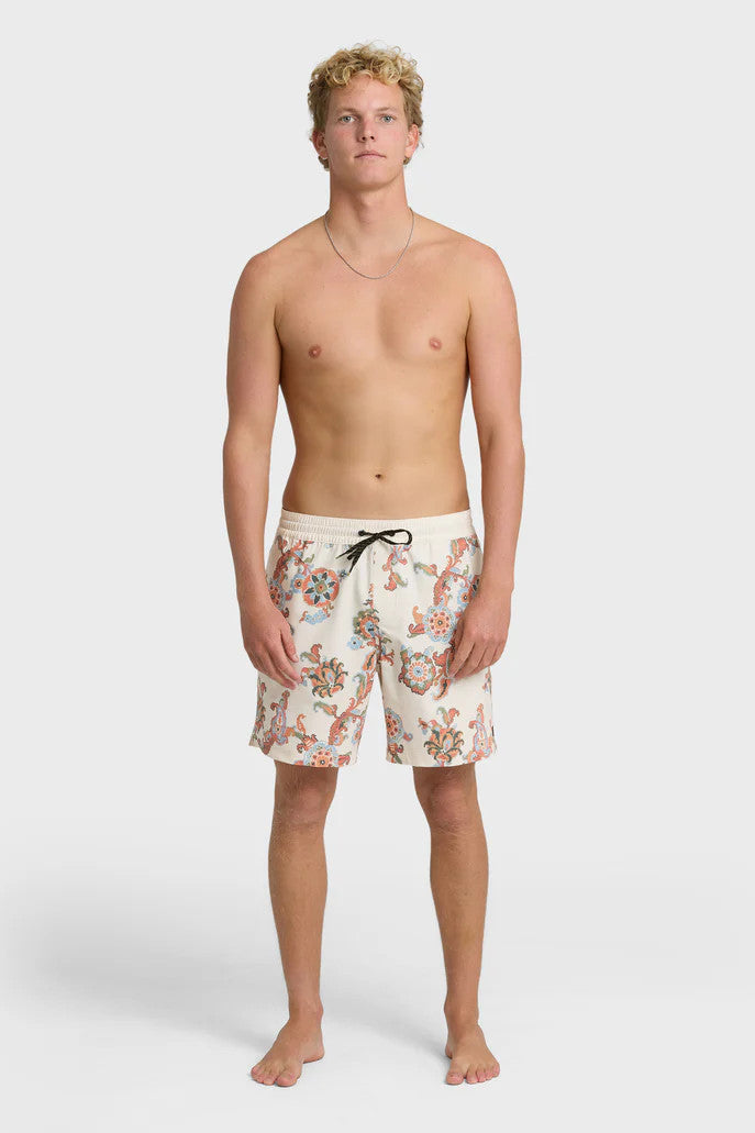 A man wearing cream boardshorts with a floral paisley pattern, elastic waist and drawstring on a white background.