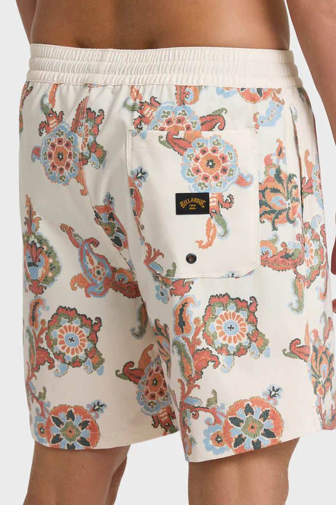 A man wearing cream boardshorts with a floral paisley pattern, elastic waist and drawstring on a white background.