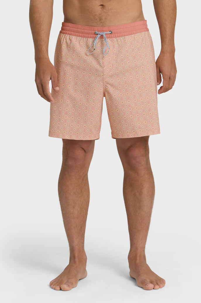 A man wearing peach-colored boardshorts with a tonal pattern, elastic waist and drawstring on a white background.