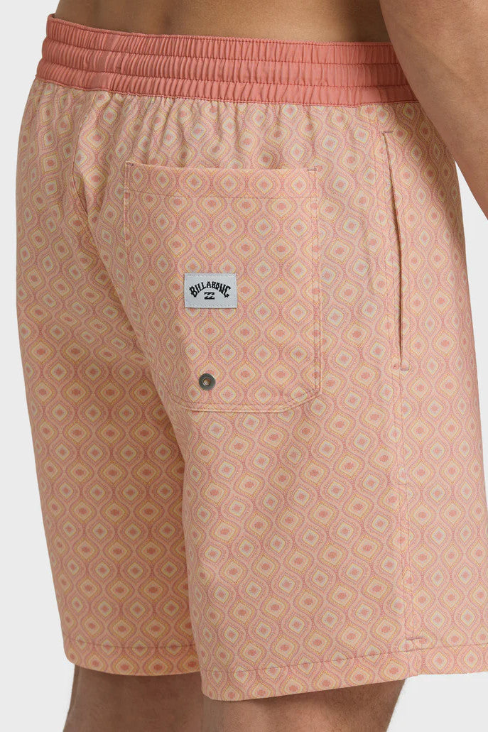 A man wearing peach-colored boardshorts with a tonal pattern, elastic waist and drawstring on a white background.