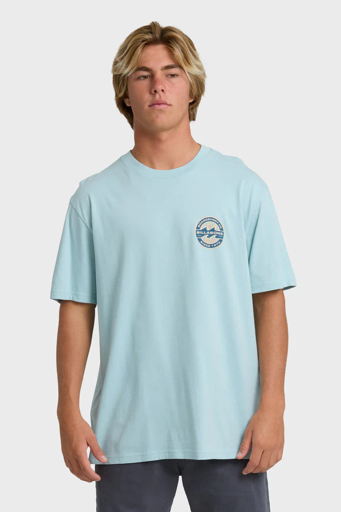 Man wearing a light blue t-shirt with a logo on a white background