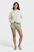 Woman wearing a white sweater and light green shorts on a white background