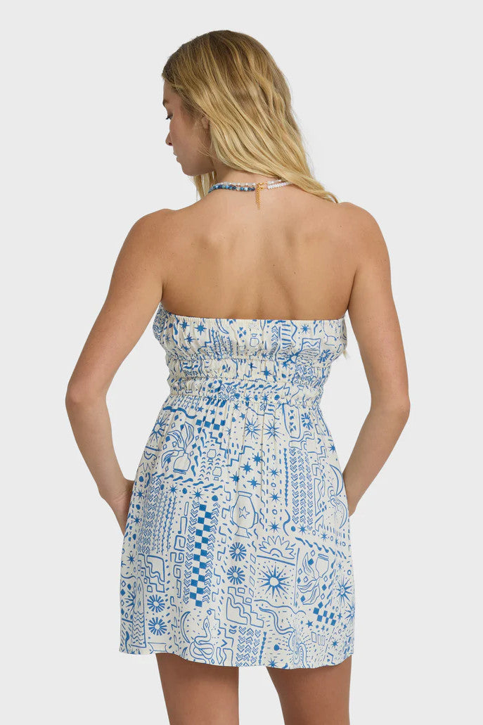 Woman wearing a blue and white patterned dress on a plain background