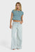 Woman wearing a blue crop top and light blue jeans on a white background