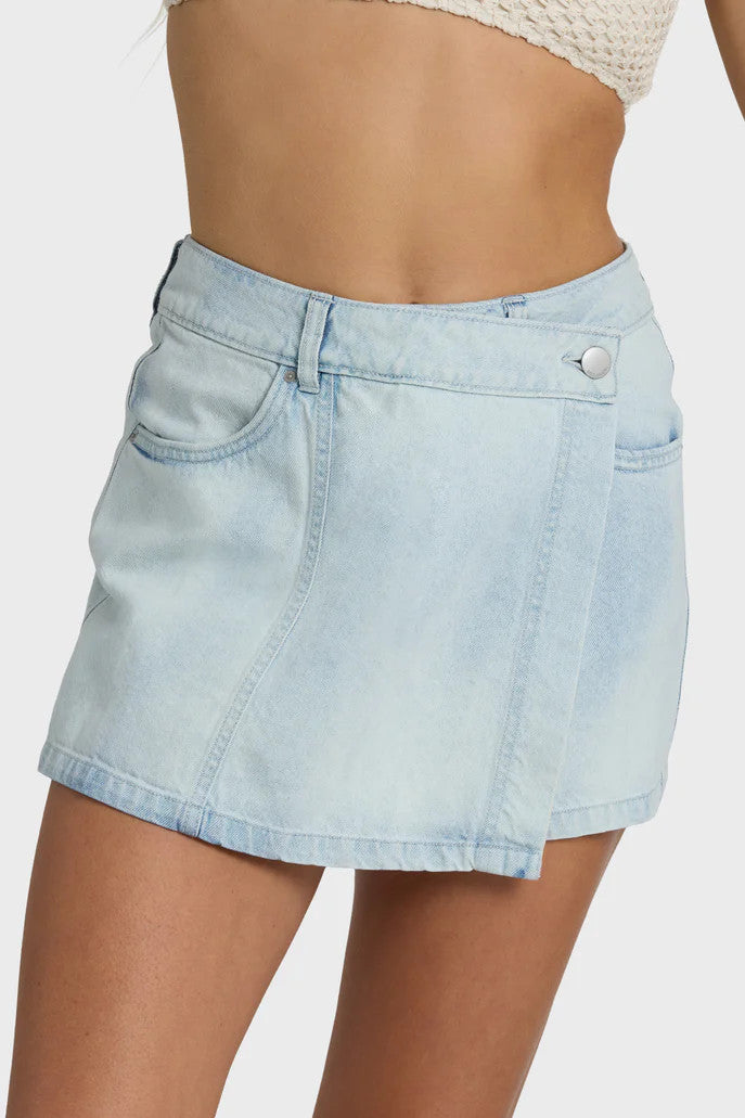 Woman wearing a textured bralette and denim skort on white background