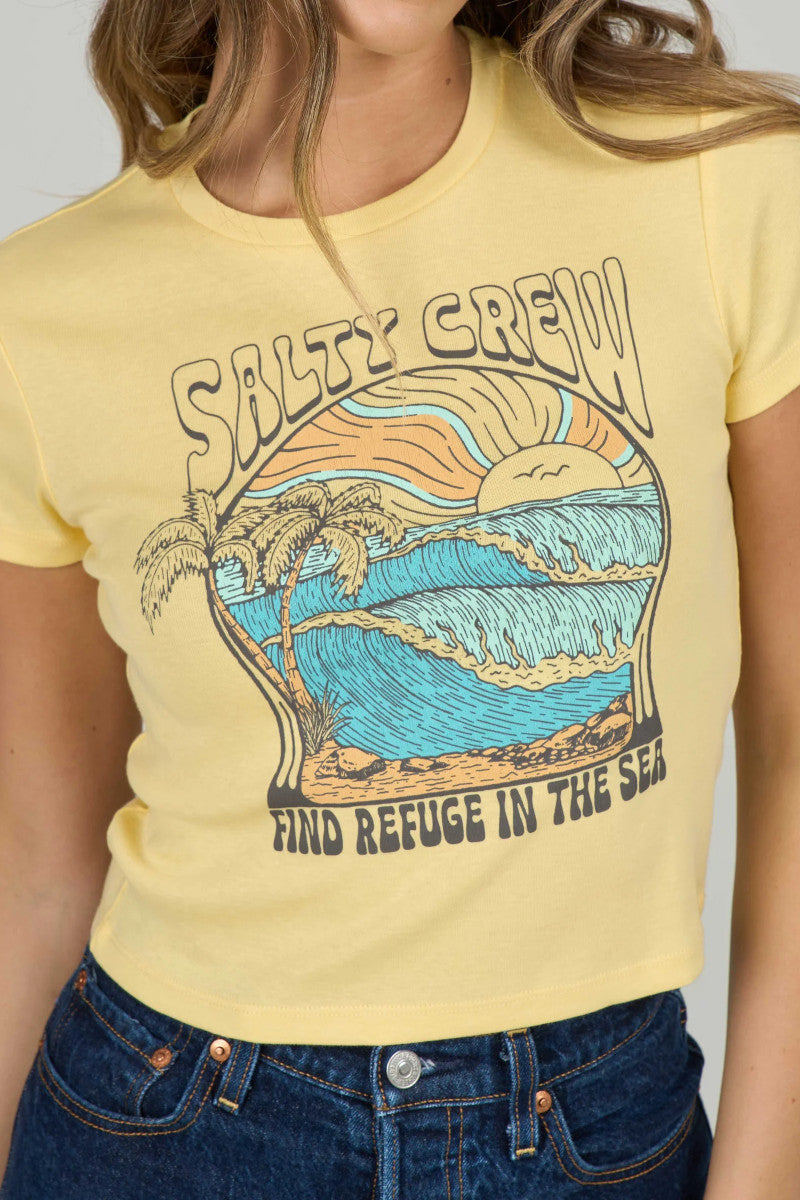 Woman wearing a yellow t-shirt with a beach graphic that says "Salty Crew" and "Find Refuge in the Sea"